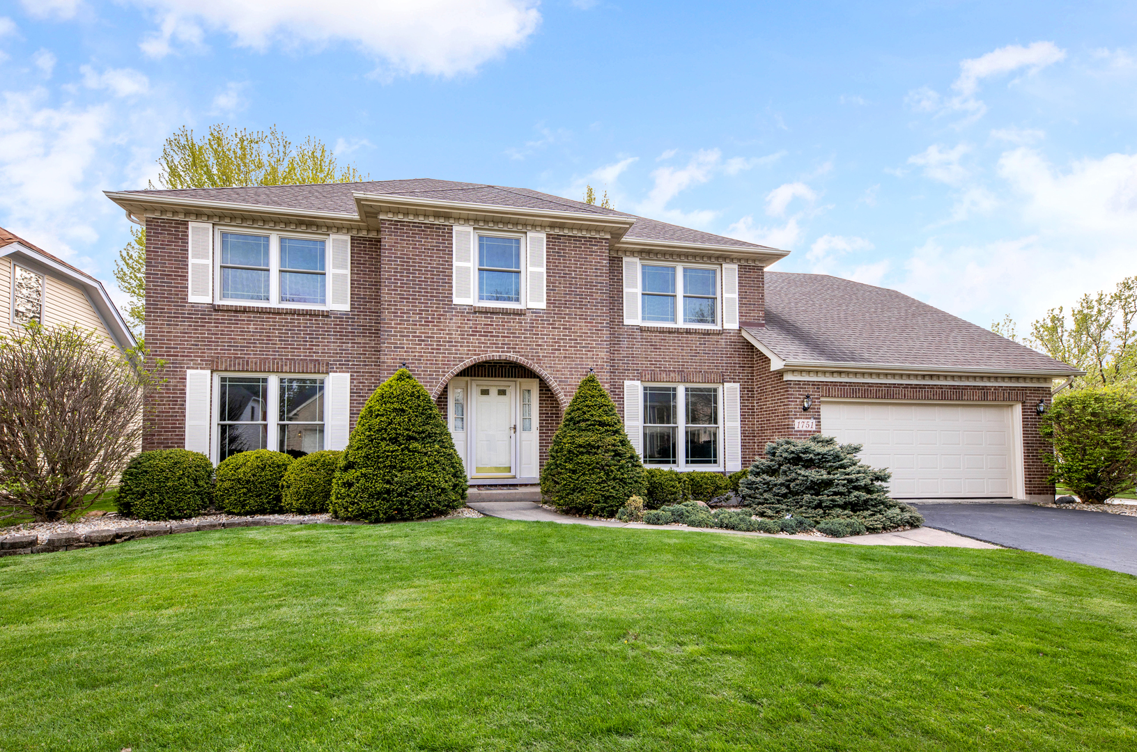 a front view of house with yard and green space