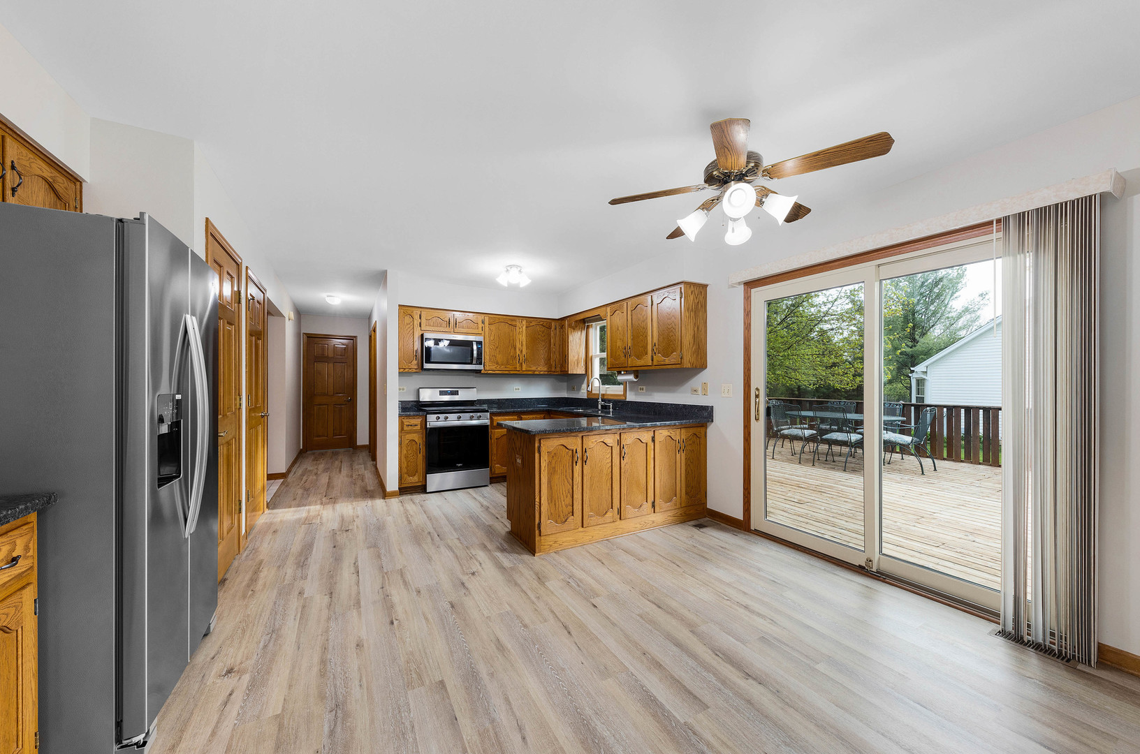 1751 Mundelein Road Naperville, IL 60565 - Photo 12 of 37 a open kitchen with stainless steel appliances granite countertop a refrigerator a stove a sink dishwasher and a dining table with wooden floor