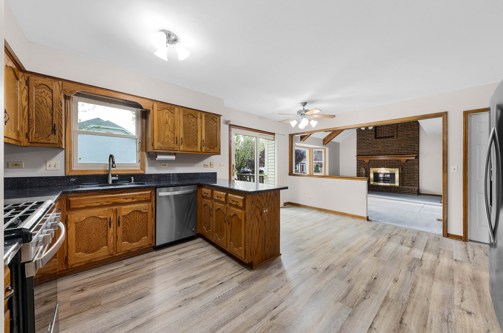 1751 Mundelein Road Naperville, IL 60565 - Photo 9 of 37 a large kitchen with granite countertop wooden floors a stove a sink and a window