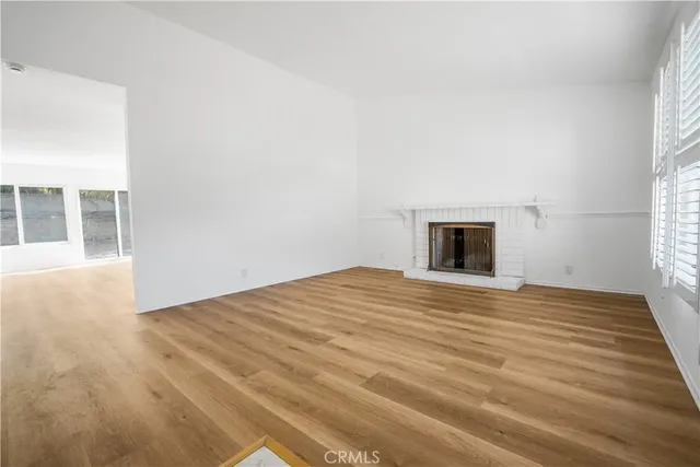 a view of a big room with wooden floor and windows