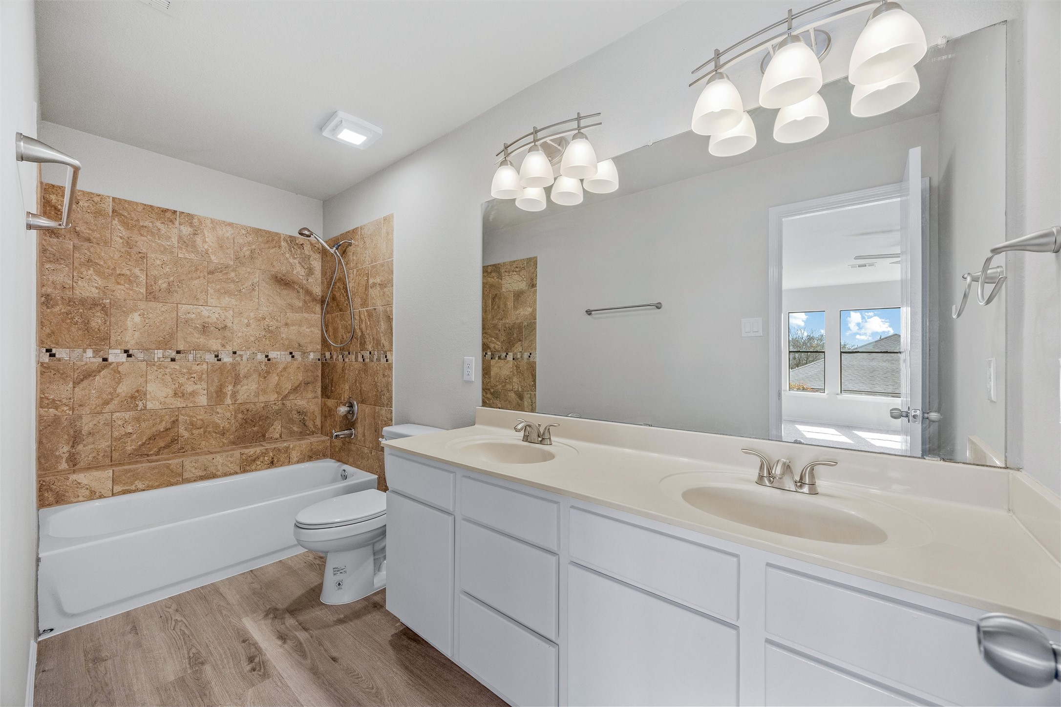 7541 Redrick Drive Austin, TX 78747 - Photo 31 of 40 Bathroom featuring shower combination, toilet, wood finished floors, and a sink