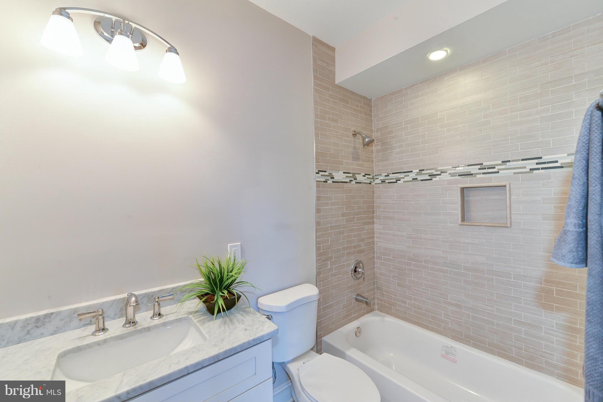 39 U Street Northeast, Unit 1 Washington, DC 20002 - Photo 13 of 27 a bathroom with a granite countertop sink a toilet and shower
