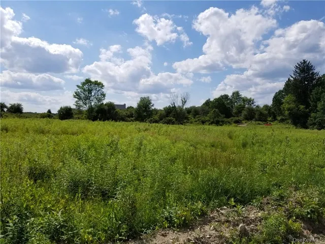 a view of a green field with wooden fence