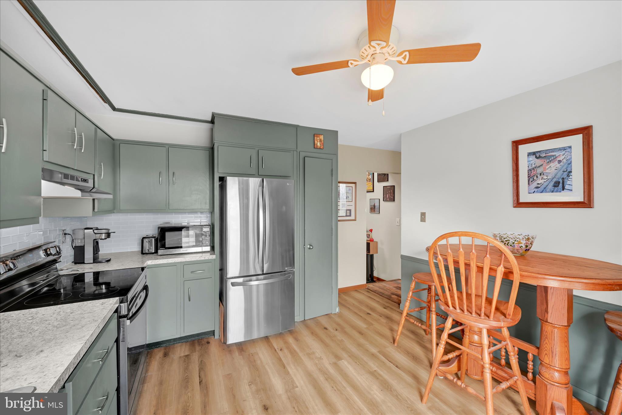 205 Pembroke Drive Reading, PA 19607 - Photo 12 of 40 a kitchen with stainless steel appliances granite countertop a refrigerator a sink dishwasher a stove and a dining table with wooden floor