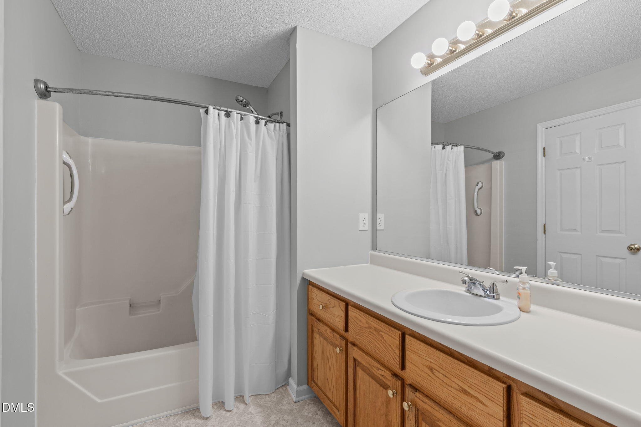 46 Budd Godwin Lane Dunn, NC 28334 - Photo 20 of 33 a bathroom with a granite countertop sink a mirror a vanity and a bathtub