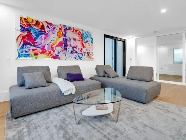 a living room with furniture and painting on the wall