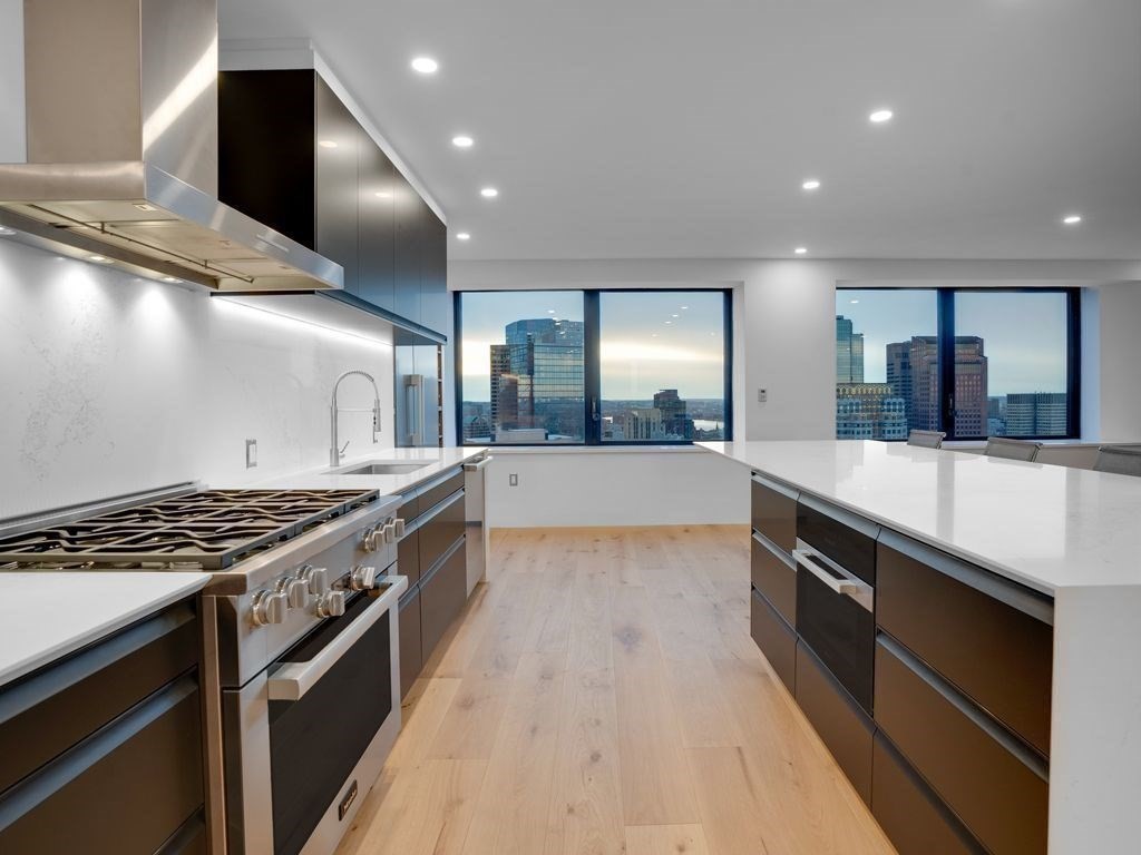 65 East India Row, Unit PH B Boston, MA 02110 - Photo 7 of 23 a large kitchen with stainless steel appliances a stove and a sink