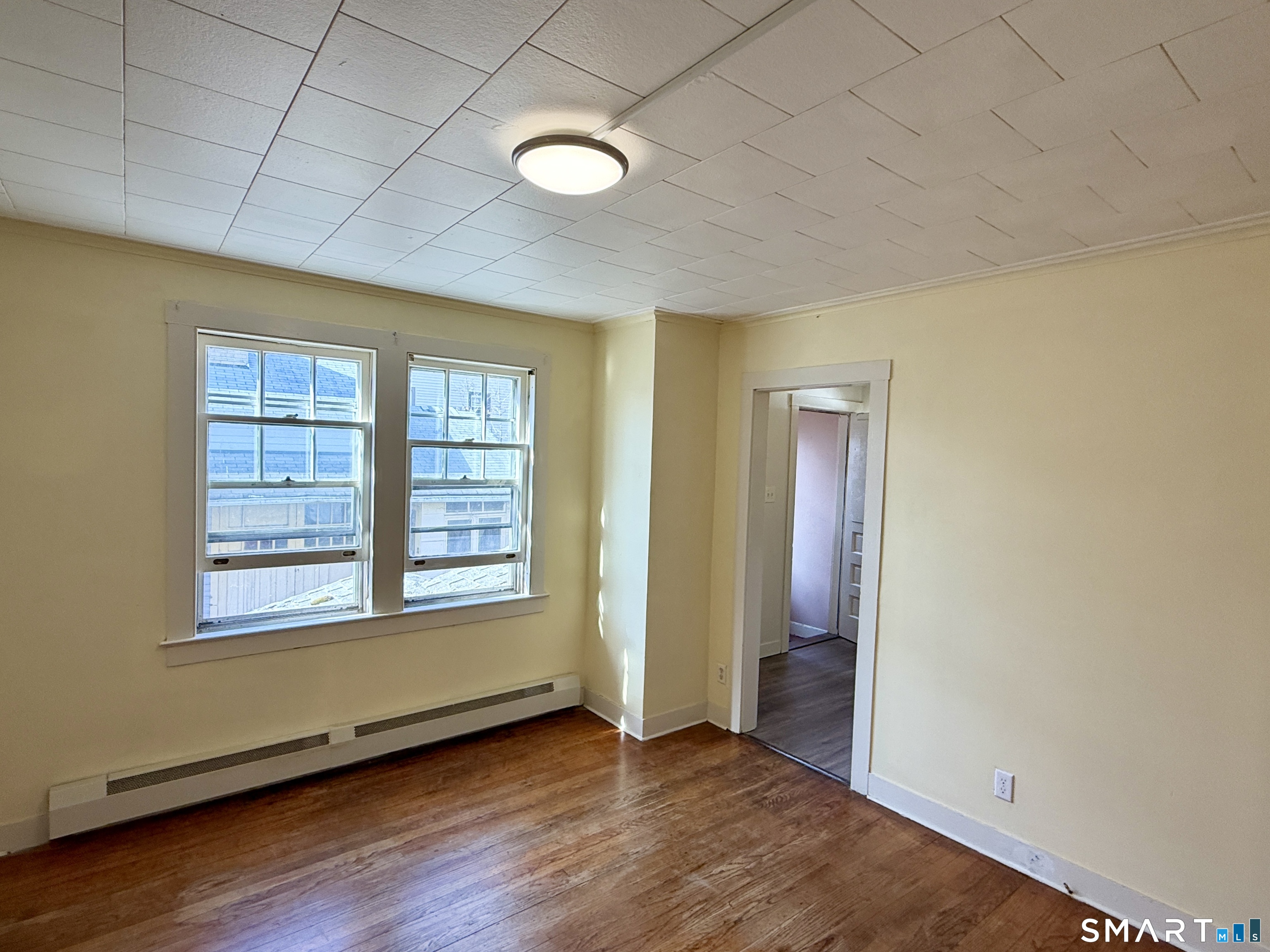 23 Farnham Avenue Torrington, CT 06790 - Photo 2 of 11 an empty room with wooden floor and windows