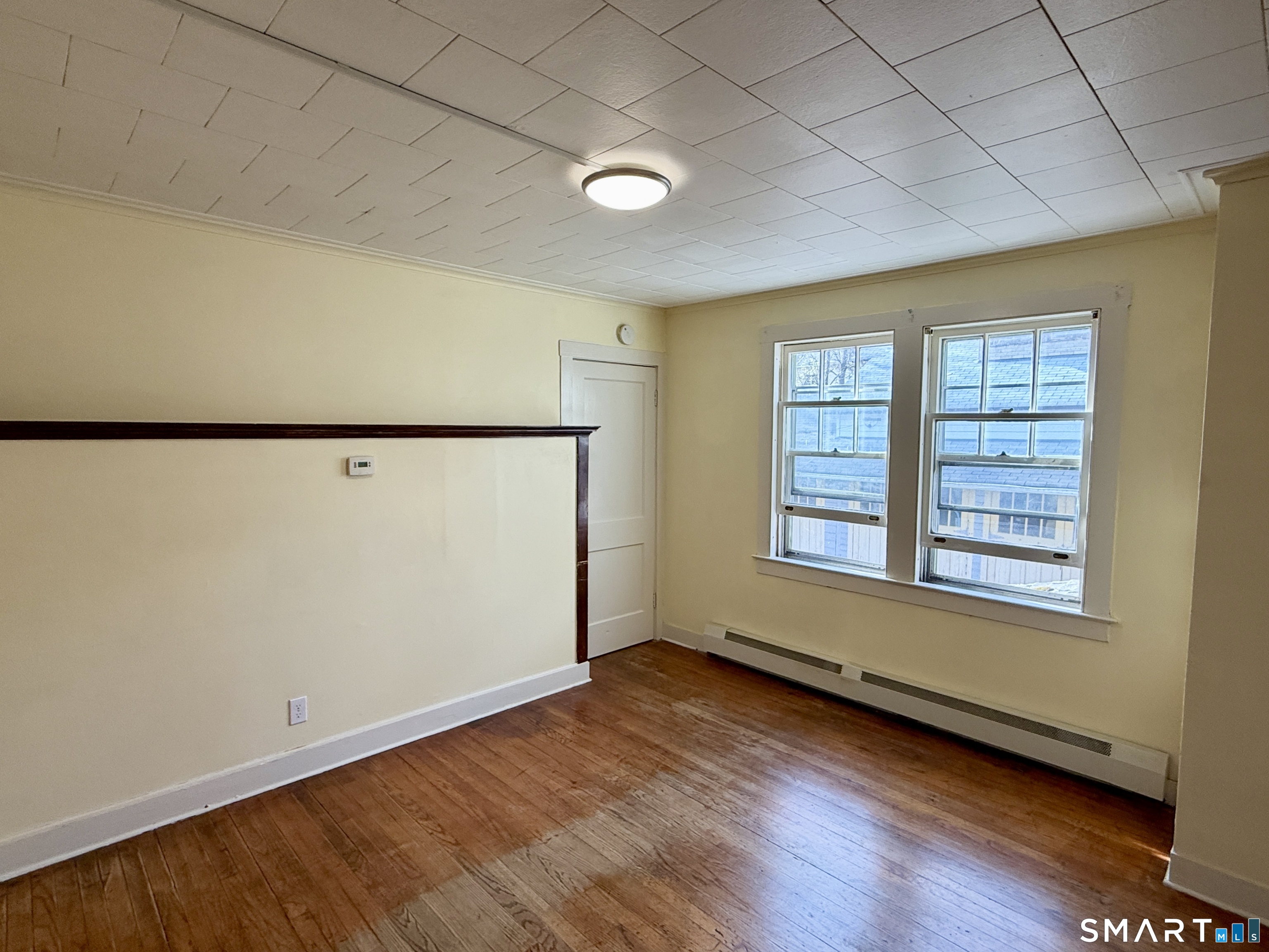 23 Farnham Avenue Torrington, CT 06790 - Photo 3 of 11 an empty room with wooden floor and window