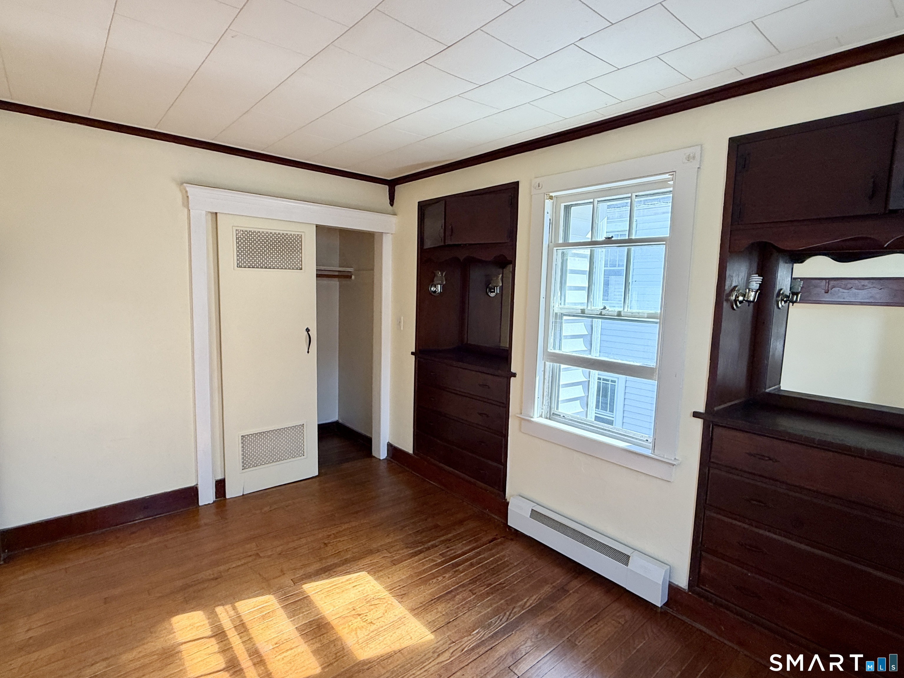 23 Farnham Avenue Torrington, CT 06790 - Photo 7 of 11 an empty room with wooden floor cabinet and windows