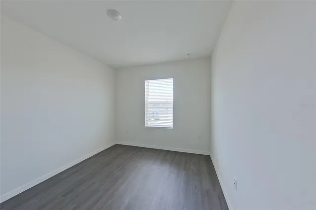 a view of a small space with wooden floor and a window