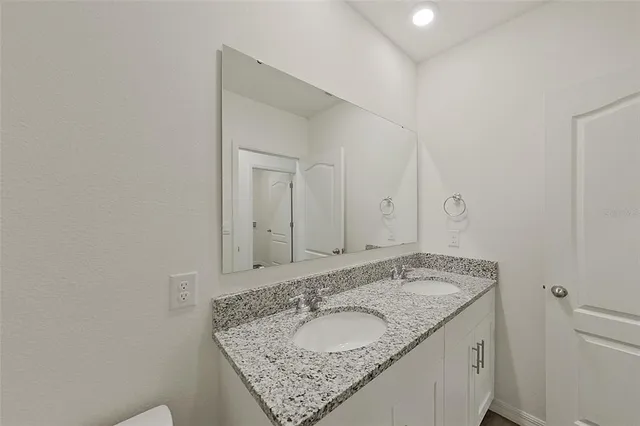 a bathroom with a granite countertop sink toilet and bathtub