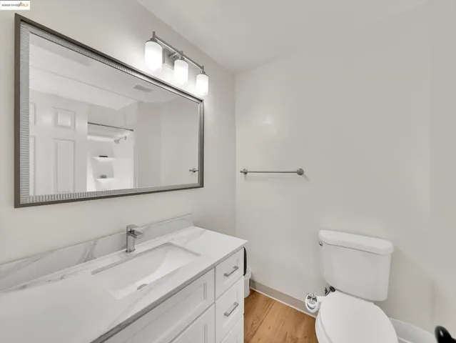 a bathroom with a granite countertop toilet sink and mirror