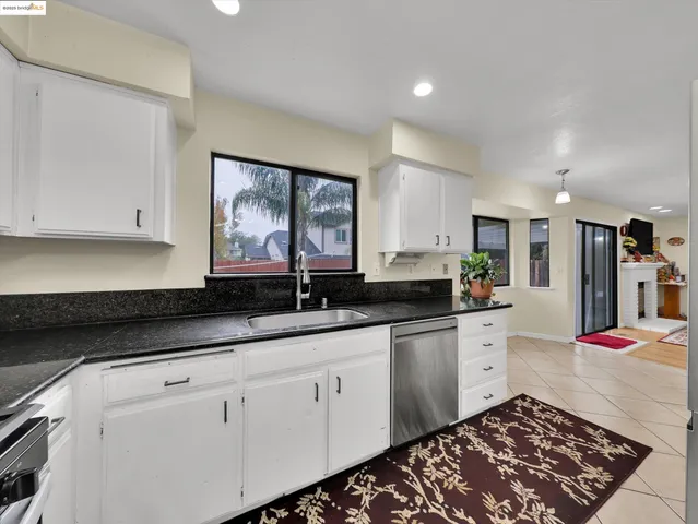 a kitchen with granite countertop white cabinets and white appliances