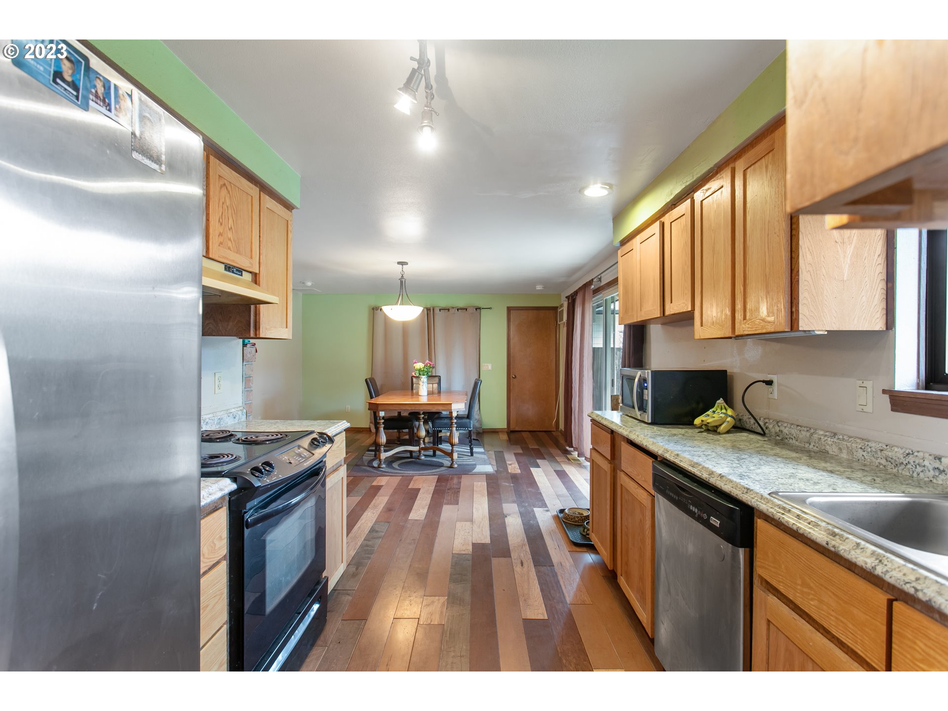 12705 Southeast Kelly Street Portland, OR 97236 - Photo 11 of 33 a kitchen view with granite countertop a stove a sink and a refrigerator