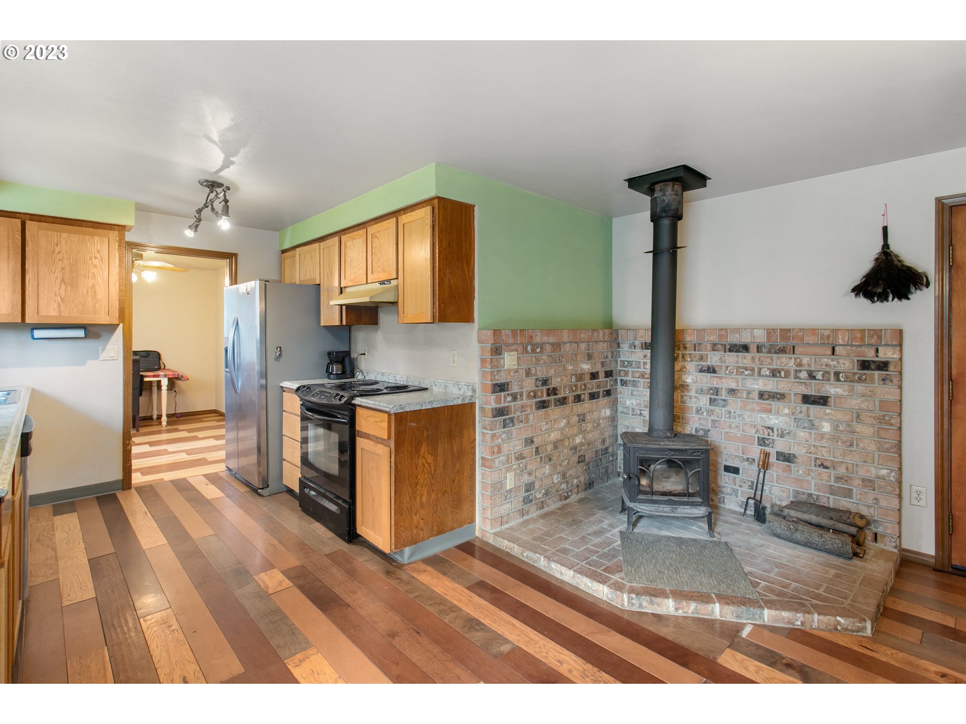 12705 Southeast Kelly Street Portland, OR 97236 - Photo 23 of 33 a kitchen with stainless steel appliances kitchen island granite countertop a stove a sink and a wooden floors