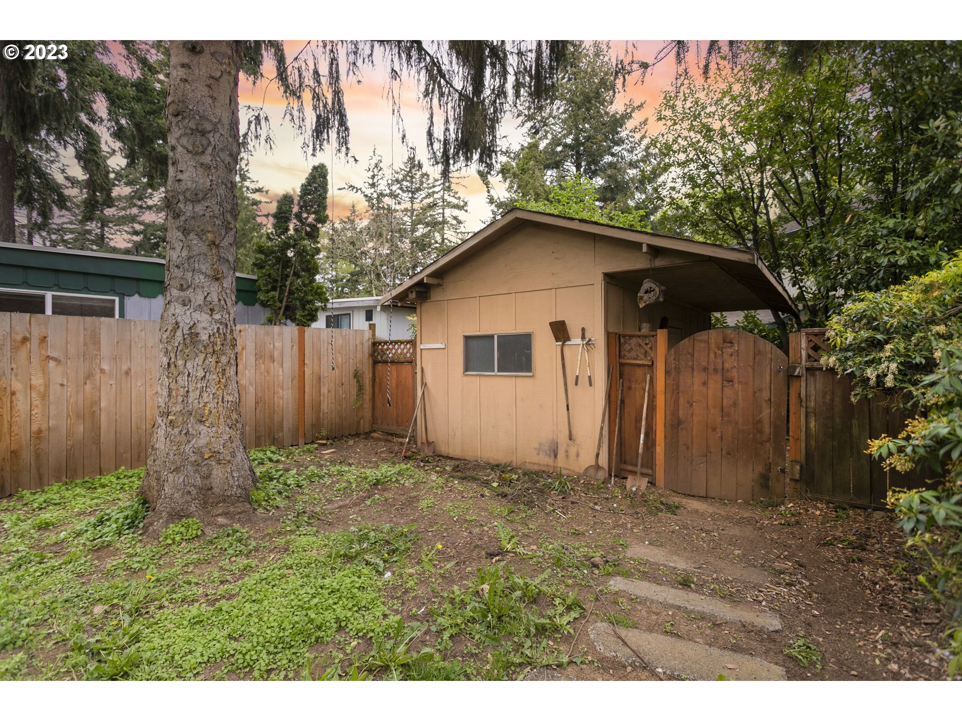 12705 Southeast Kelly Street Portland, OR 97236 - Photo 31 of 33 a view of a wooden house with a small yard and large trees