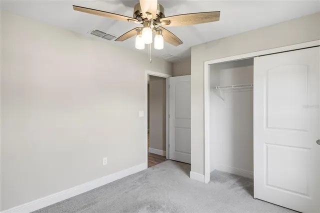 an empty room with a ceiling fan and a fan