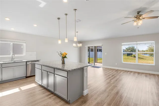 a kitchen with stainless steel appliances granite countertop a sink a stove and a wooden floors