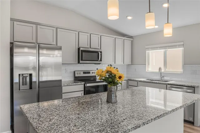 a kitchen with kitchen island a counter space cabinets and stainless steel appliances