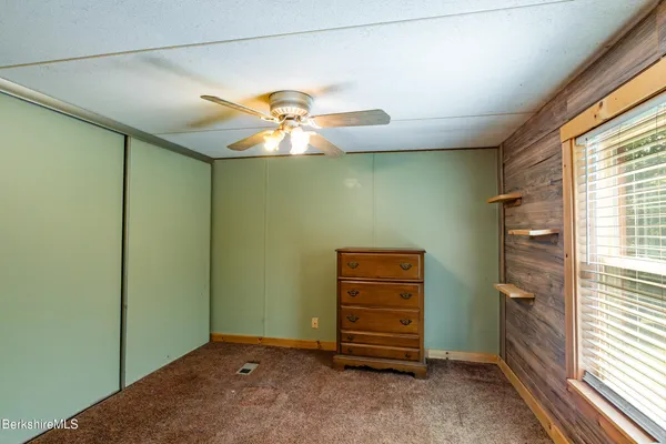an empty room with a ceiling fan and a window