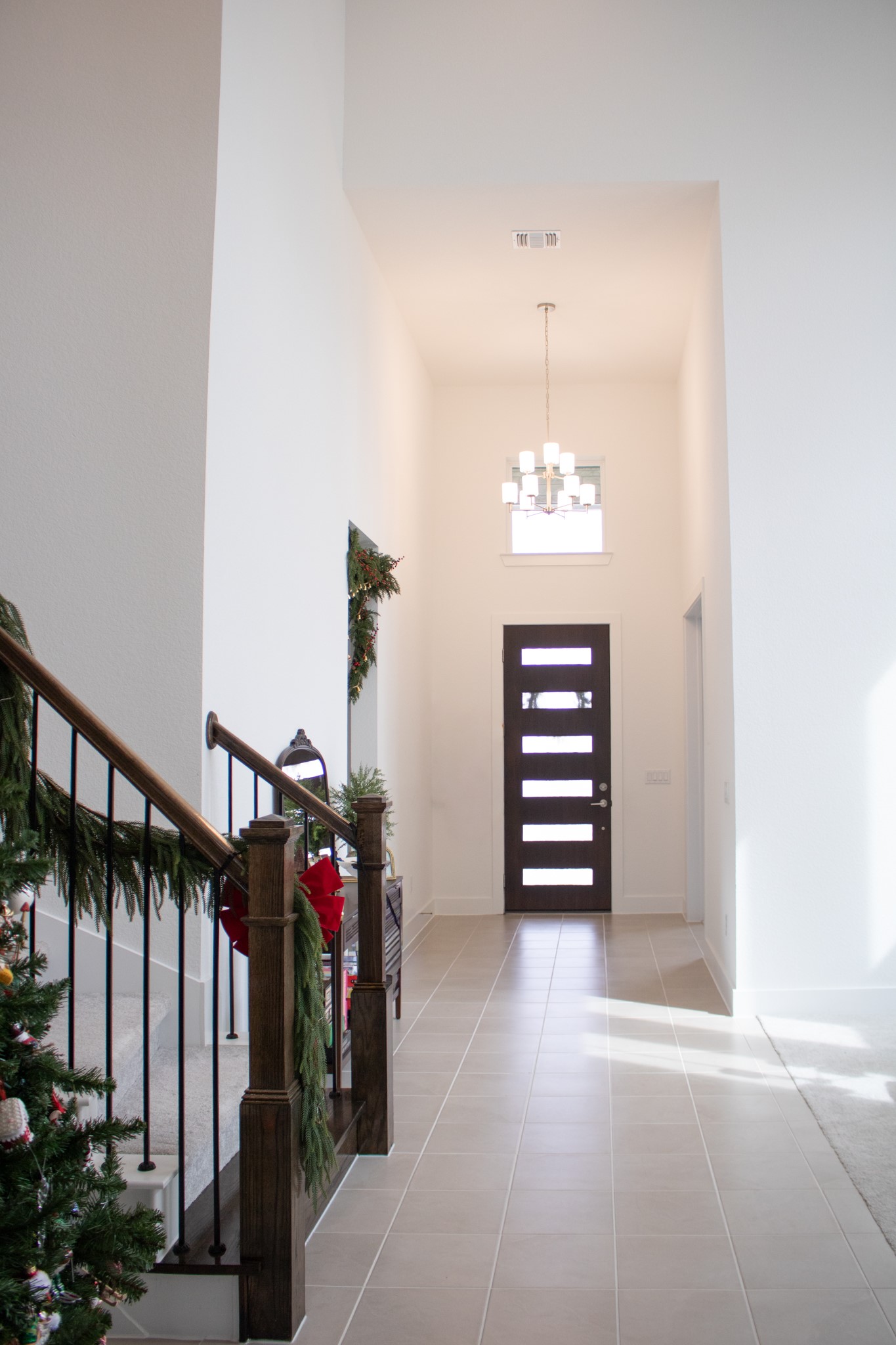1709 Novara Trail Leander, TX 78641 - Photo 12 of 40 Entryway featuring a high ceiling, light tile patterned floors, and a chandelier