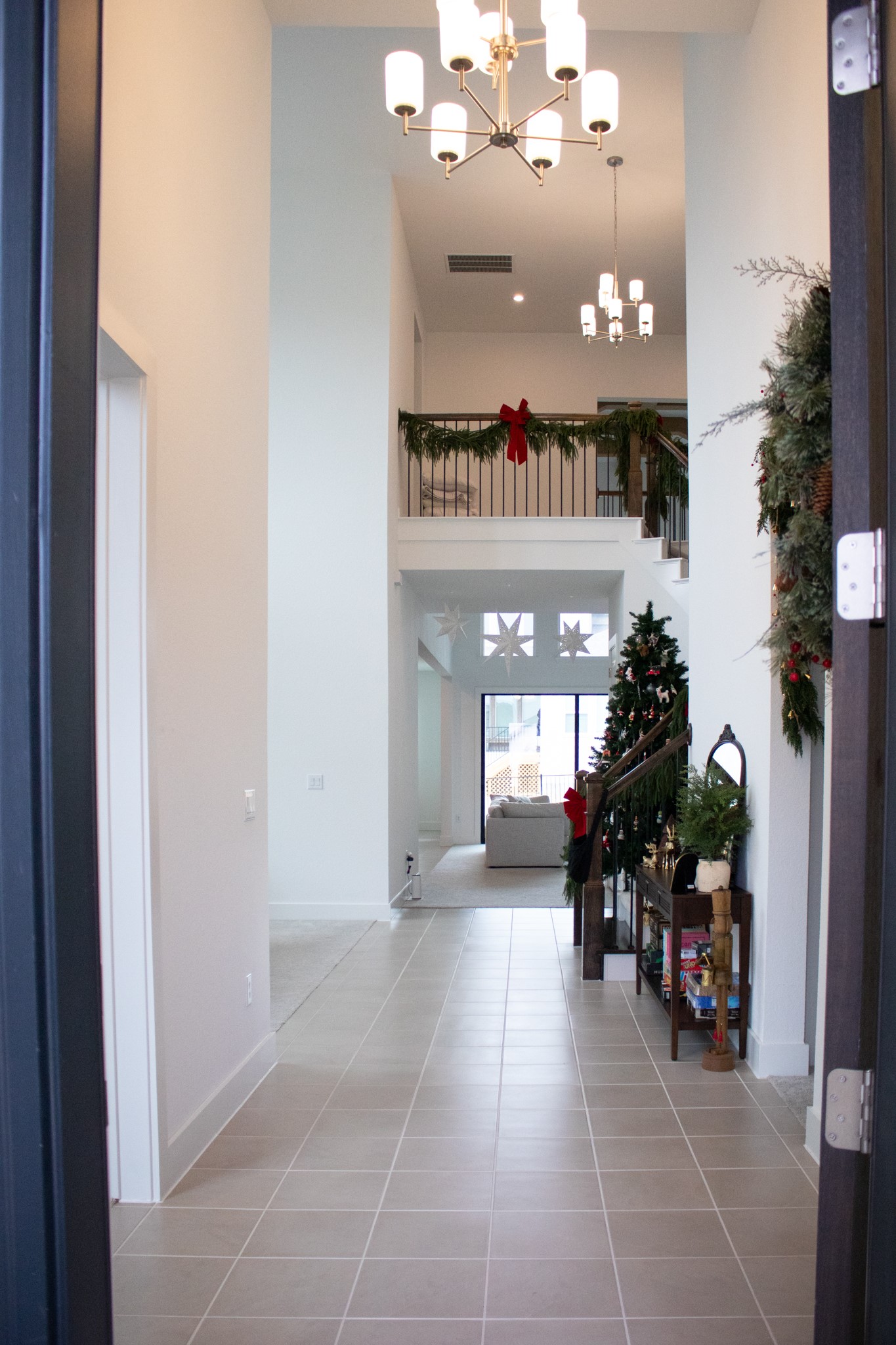 1709 Novara Trail Leander, TX 78641 - Photo 2 of 40 Hallway featuring a high ceiling, a chandelier, and light tile patterned flooring