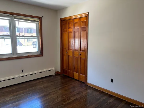 an empty room with wooden floor and window