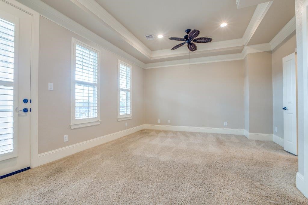46 East Rafters Row The Woodlands, TX 77380 - Photo 13 of 25 Spacious primary retreat featuring a tray ceiling, plantation shutters, and room for a sitting area.