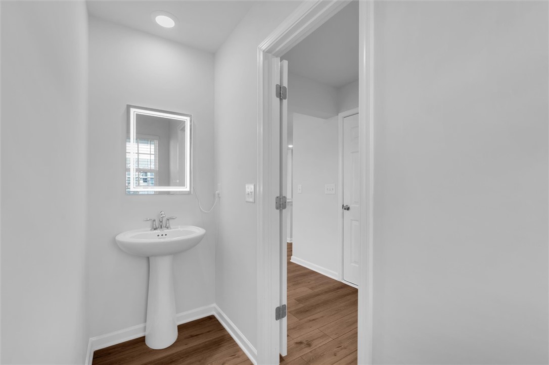 515 Brasstown Court Pendleton, SC 29670 - Photo 7 of 25 This modern half bath features a stylish pedestal sink and a sleek illuminated mirror.