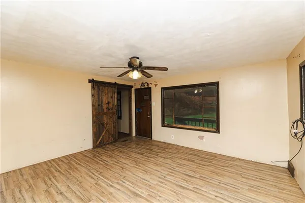 a view of a room with wooden floor and ceiling fan