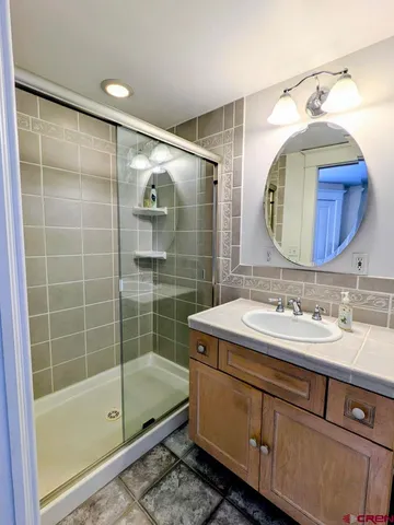 a bathroom with a sink mirror and a shower