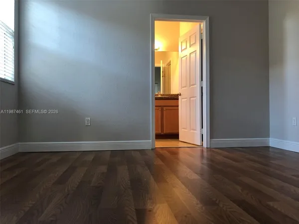 an empty room with wooden floor and a window