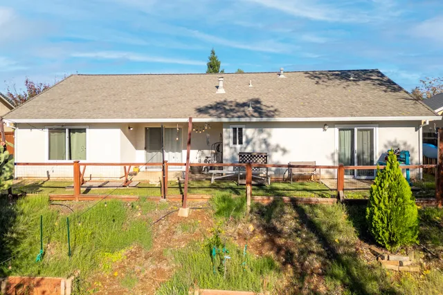 a view of swimming pool with lawn chairs and iron fence