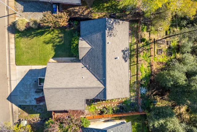 an aerial view of a house with a yard and large trees