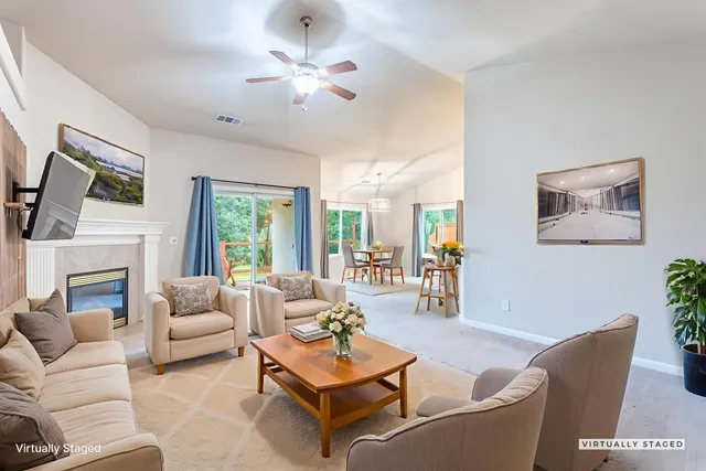 a living room with furniture a fireplace and a large mirror