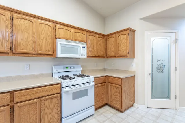 a kitchen with stainless steel appliances granite countertop white cabinets and a stove top oven
