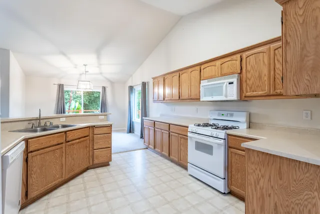 a kitchen with stainless steel appliances granite countertop a stove sink and cabinets