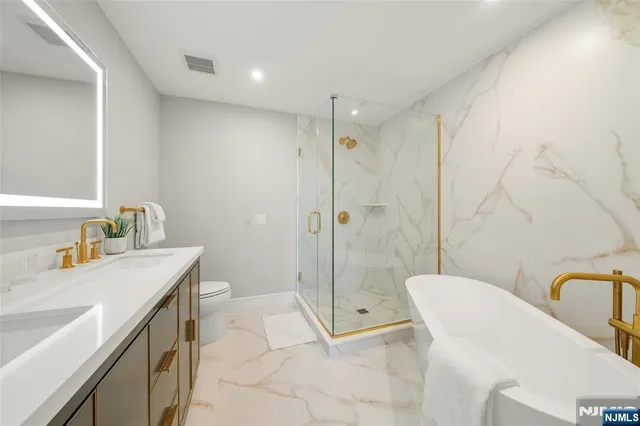 a bathroom with a toilet a sink a mirror and a window