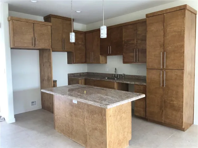 a kitchen with stainless steel appliances granite countertop a sink a refrigerator and a stove