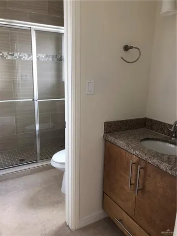 a bathroom with a granite countertop toilet and a shower