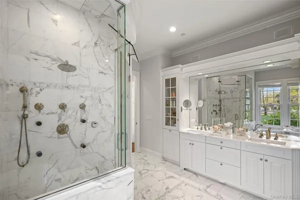 a bathroom with a double vanity sink mirror and shower