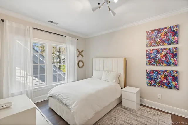 a bedroom with a large bed and a painting on the wall