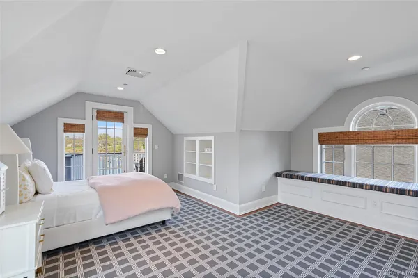 a bedroom with a bed and a large window