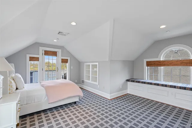 a bedroom with a bed and a large window