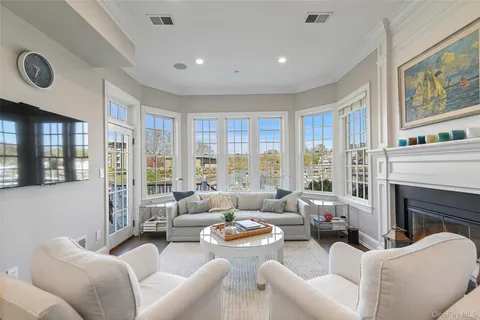 a living room with furniture large windows and a fireplace