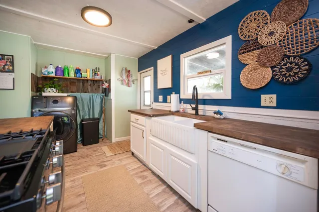 a living room with furniture couches and a dining table with wooden floor
