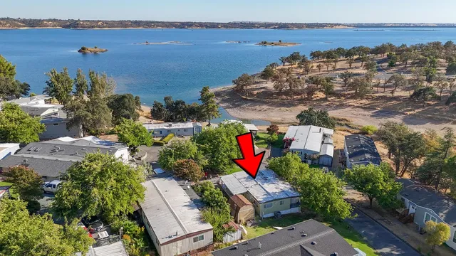 an aerial view of residential houses with outdoor space and trees