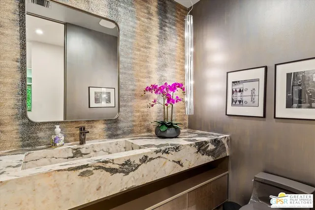 a bathroom with a granite countertop sink and a mirror