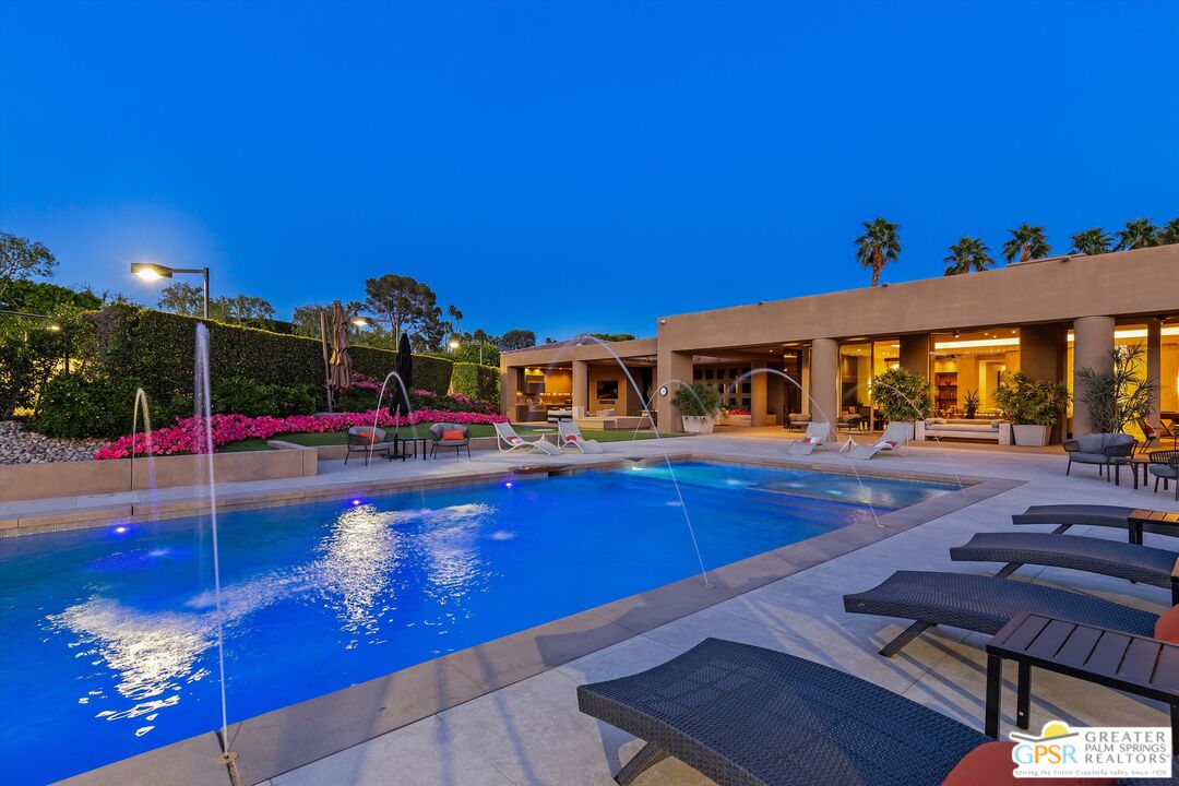 4 Big Sioux Road Rancho Mirage, CA 92270 - Photo 9 of 75 a view of a swimming pool with lawn chairs under an umbrella